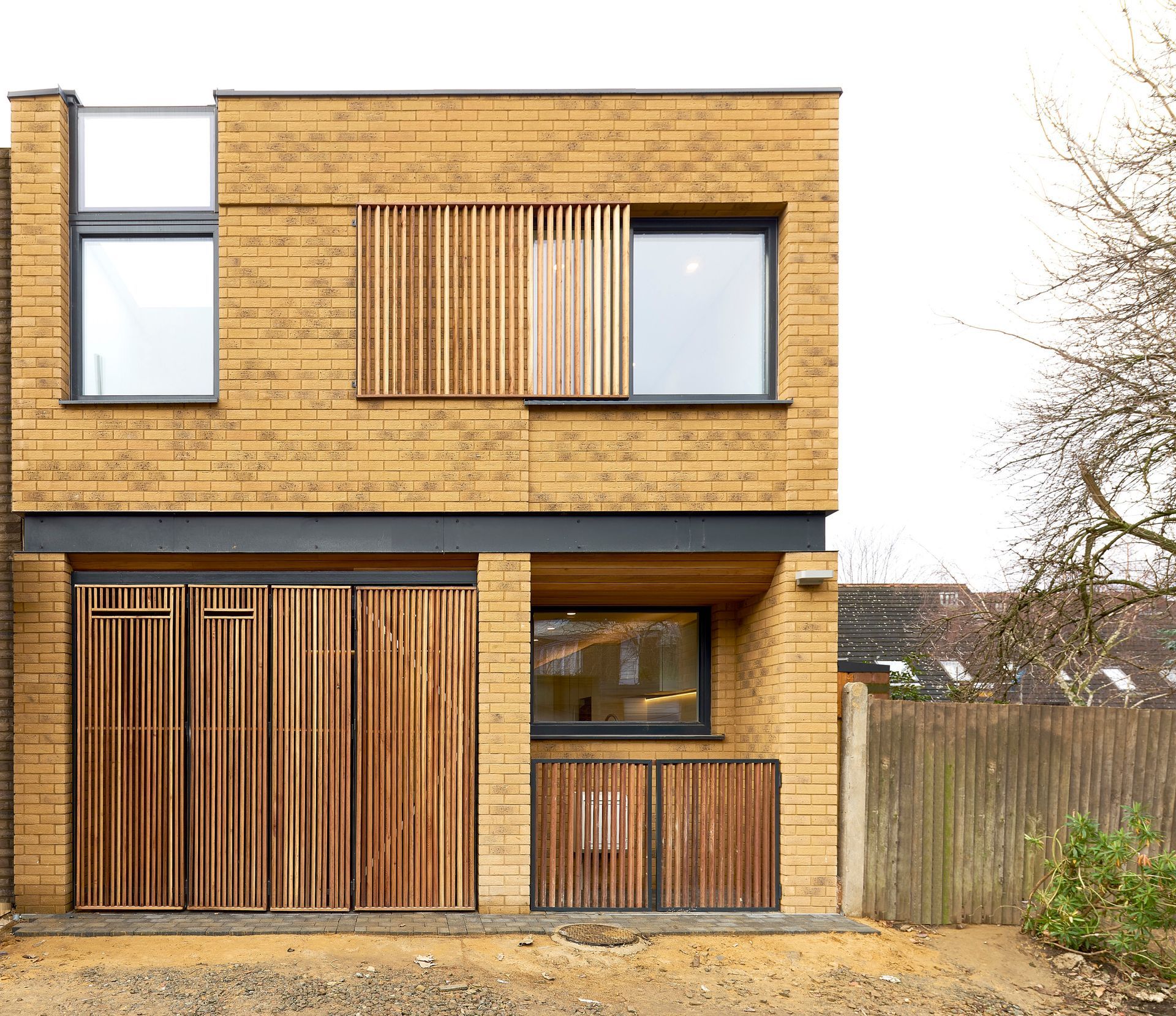 Modern two-story wooden house facade with large windows and a small front porch