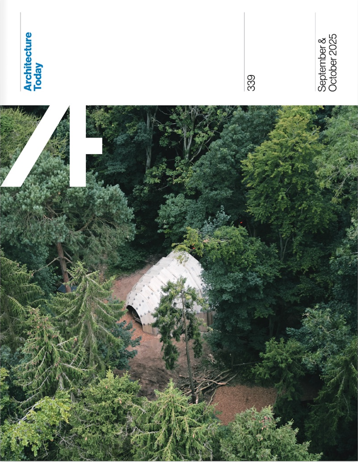 Aerial view of a small white structure nestled among dense green trees.