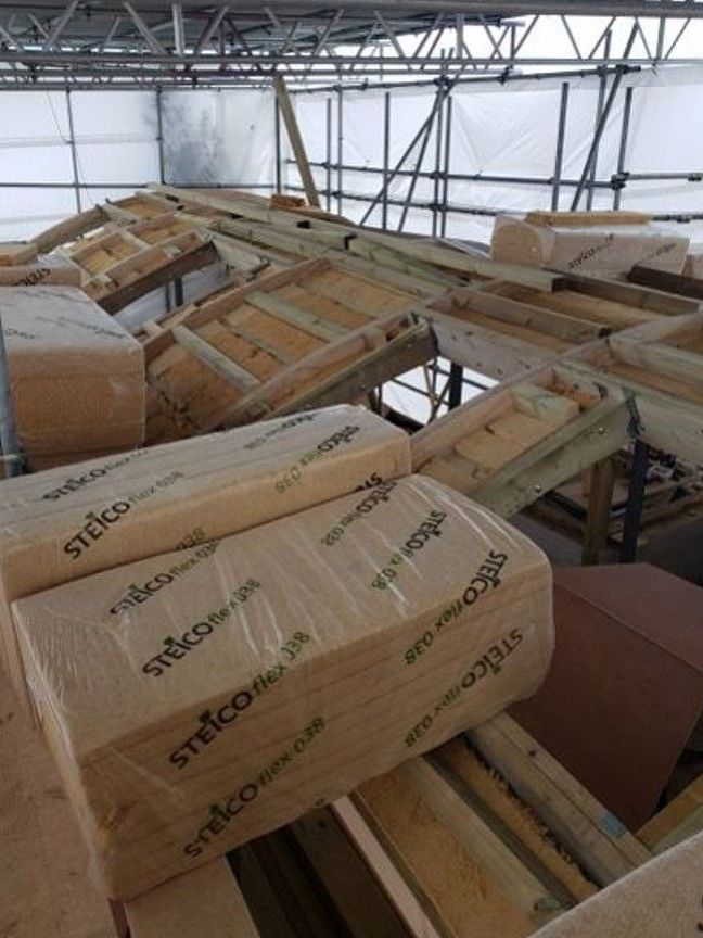 Pile of cardboard boxes and wooden beams inside an industrial warehouse under construction
