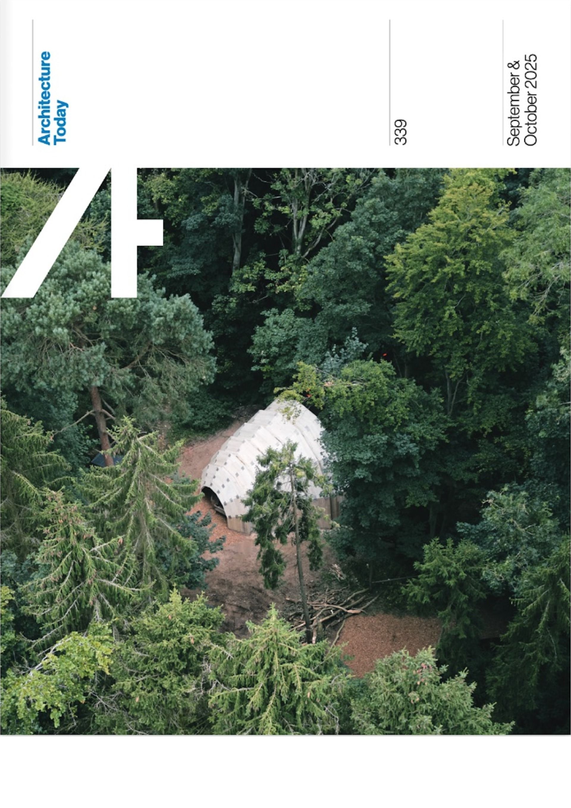 Aerial view of a white-roofed building nestled in dense green forest.