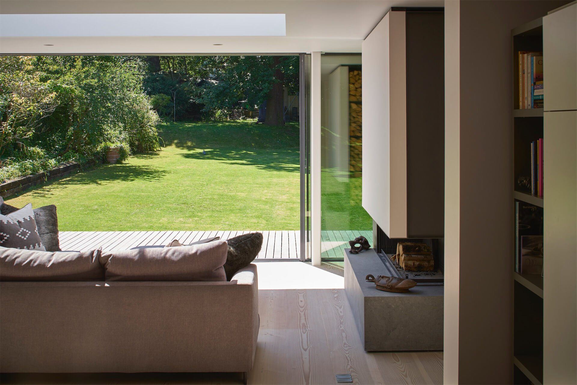 Modern living room with open sliding doors to a sunny green garden