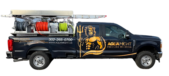 Dark blue truck with a pressure washing setup and the logo