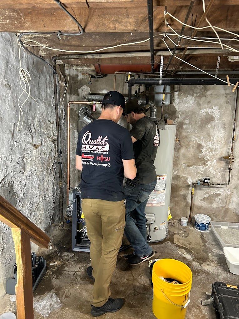 A group of men are working on a water heater in a basement.