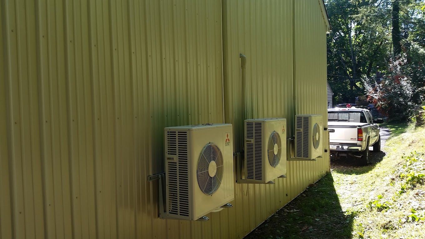 A row of air conditioners are mounted on the side of a building.