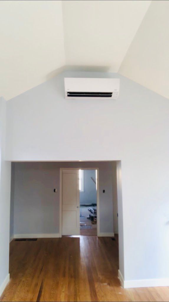 An empty room with a ceiling fan hanging from the ceiling.