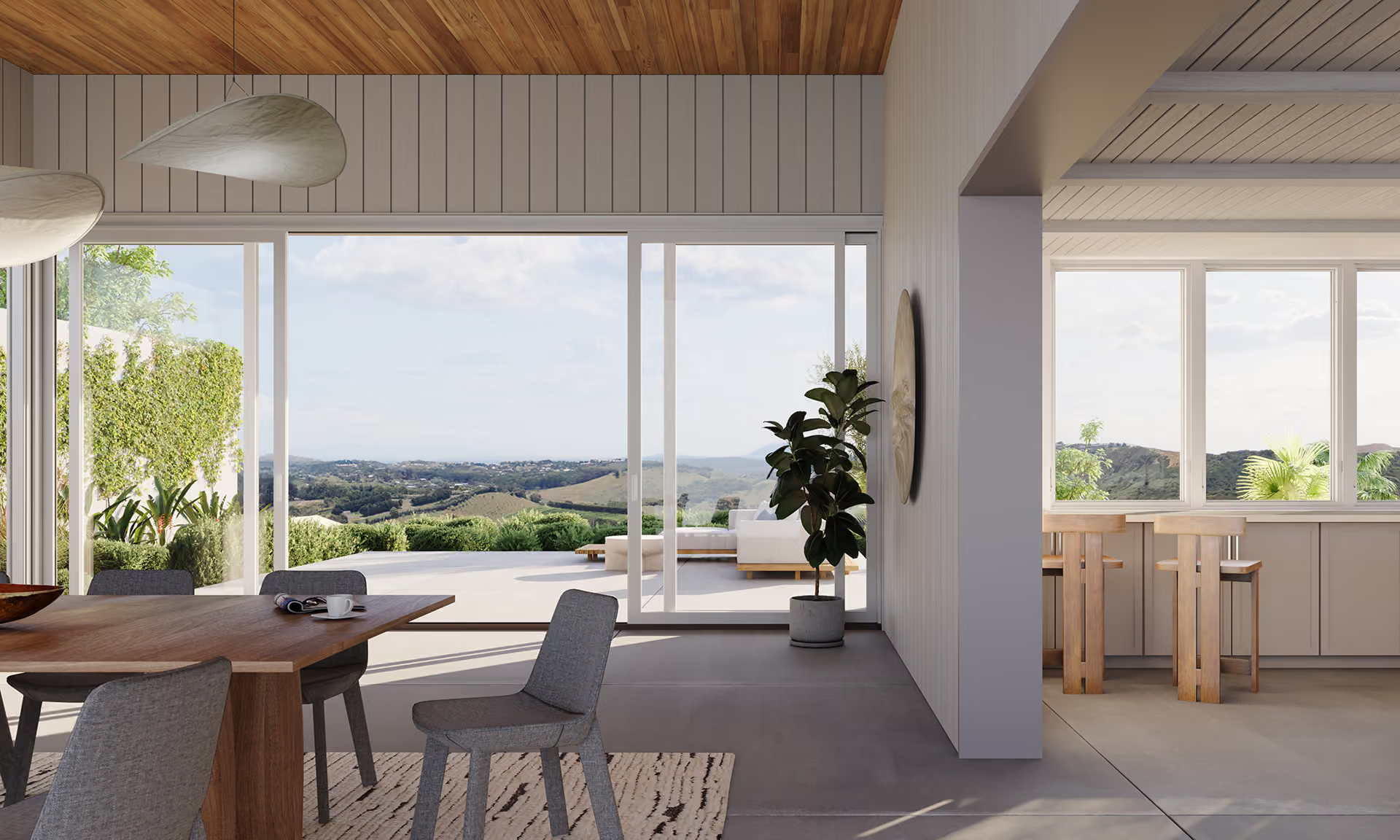 Modern open-plan living room with large windows, wood ceiling, dining table, and view of green landscape