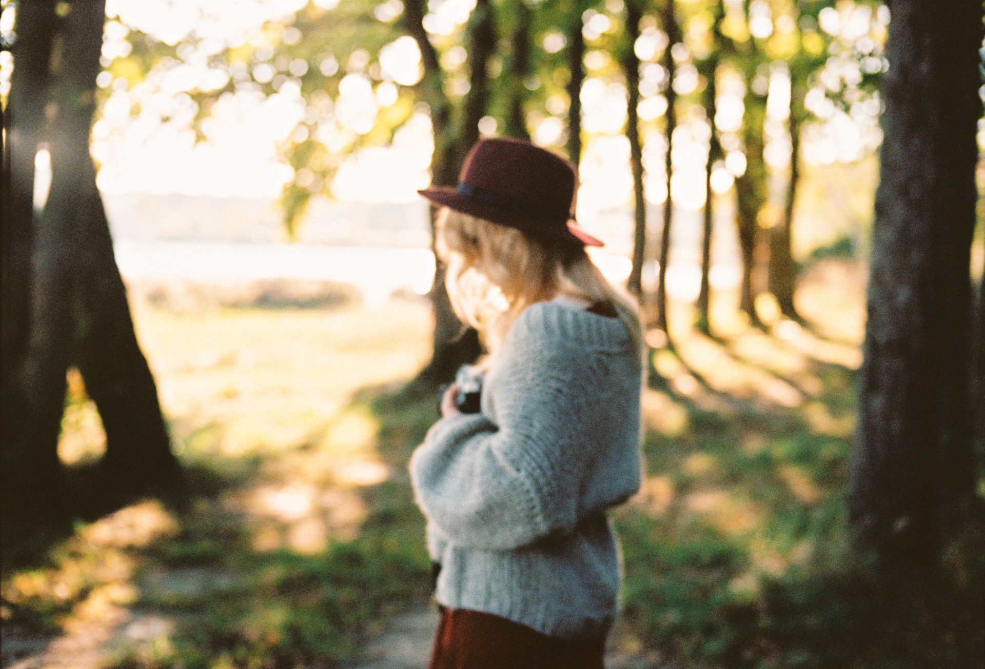 women in woods holding heard looking downward 