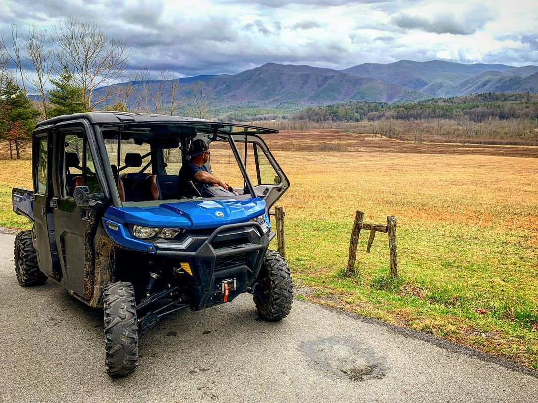Man looking at the mountain while riding on blue UTV