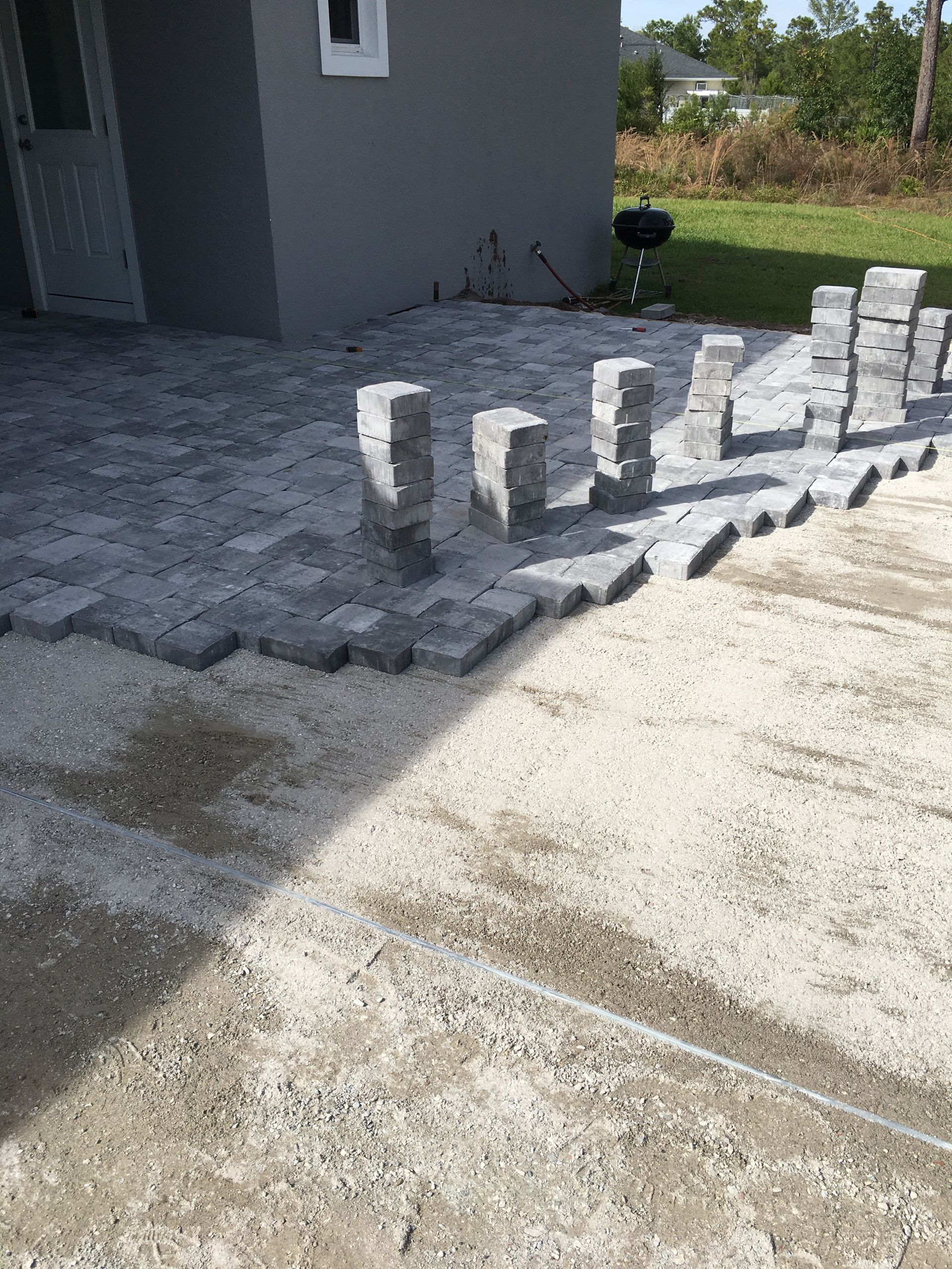 A concrete patio is being built in front of a house.