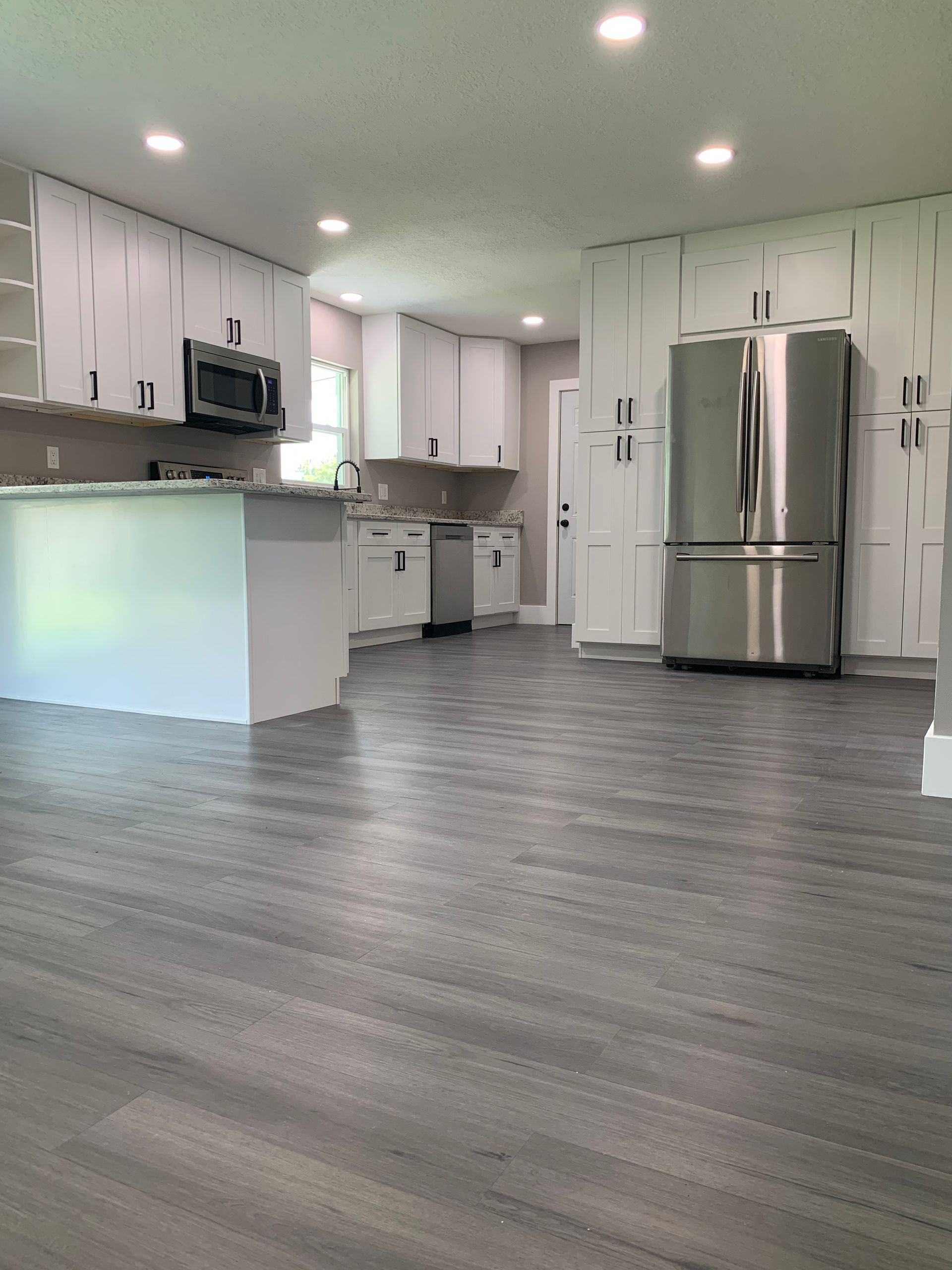 A kitchen with stainless steel appliances and white cabinets