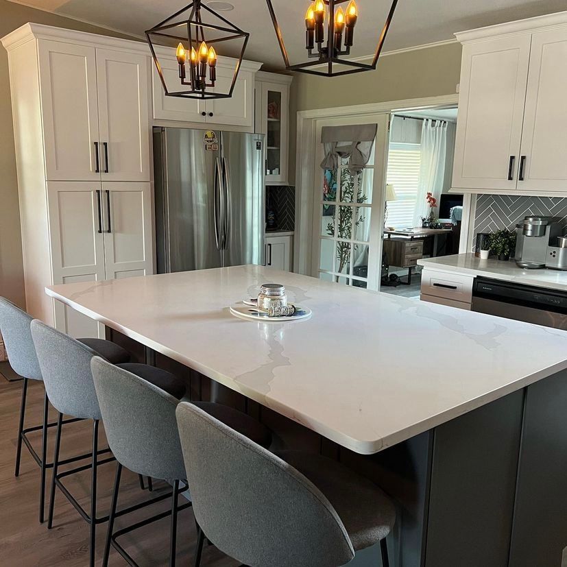 There is a large island in the middle of the kitchen with a table and chairs.