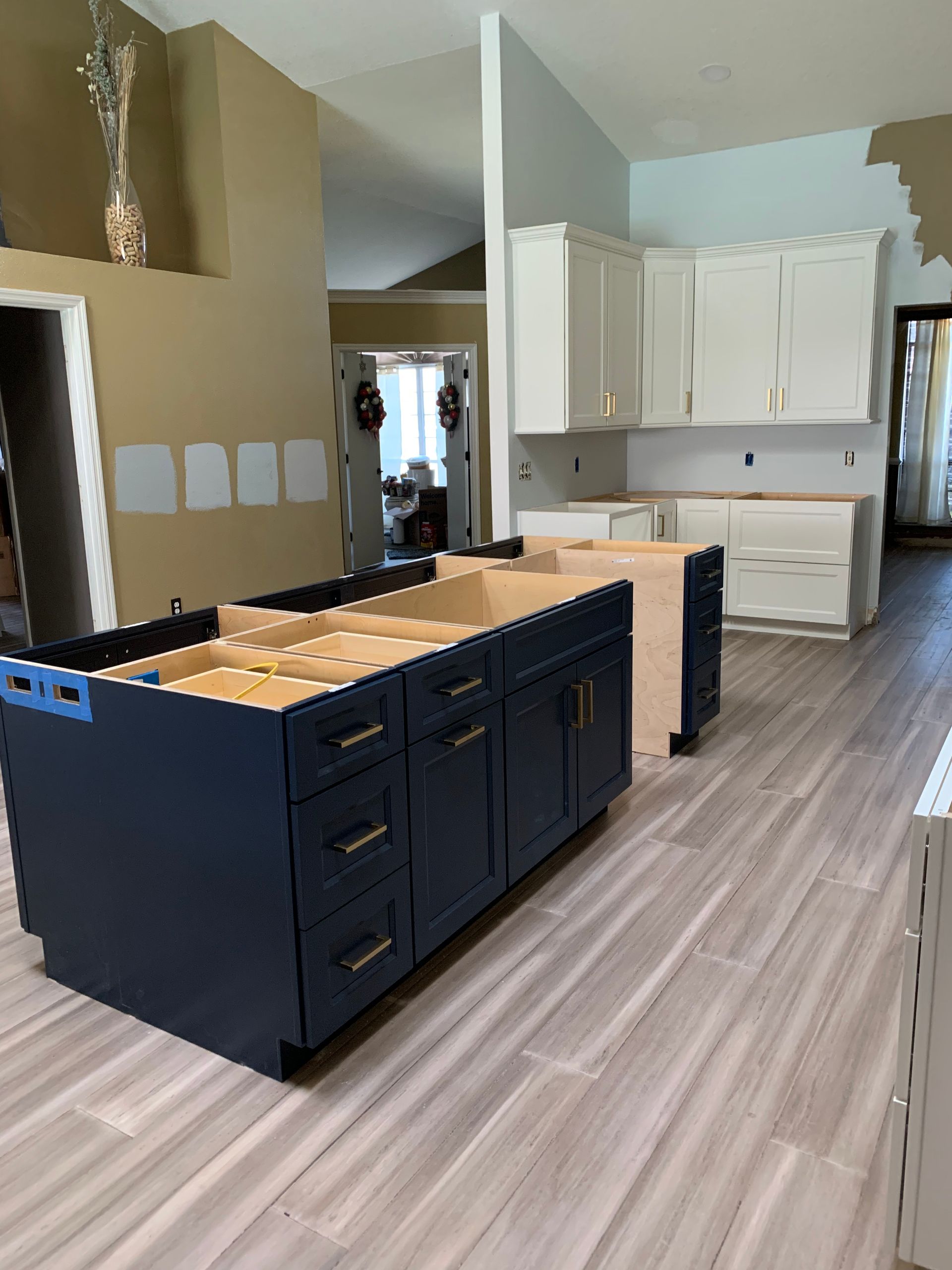 A kitchen with blue cabinets and white cabinets is being remodeled.