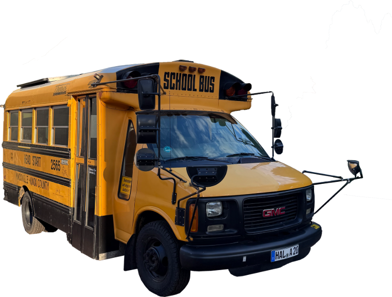 Amerikanischer Fotobox-Bus im Retro-Design parkt als Event-Highlight vor einer Hochzeitslocation.