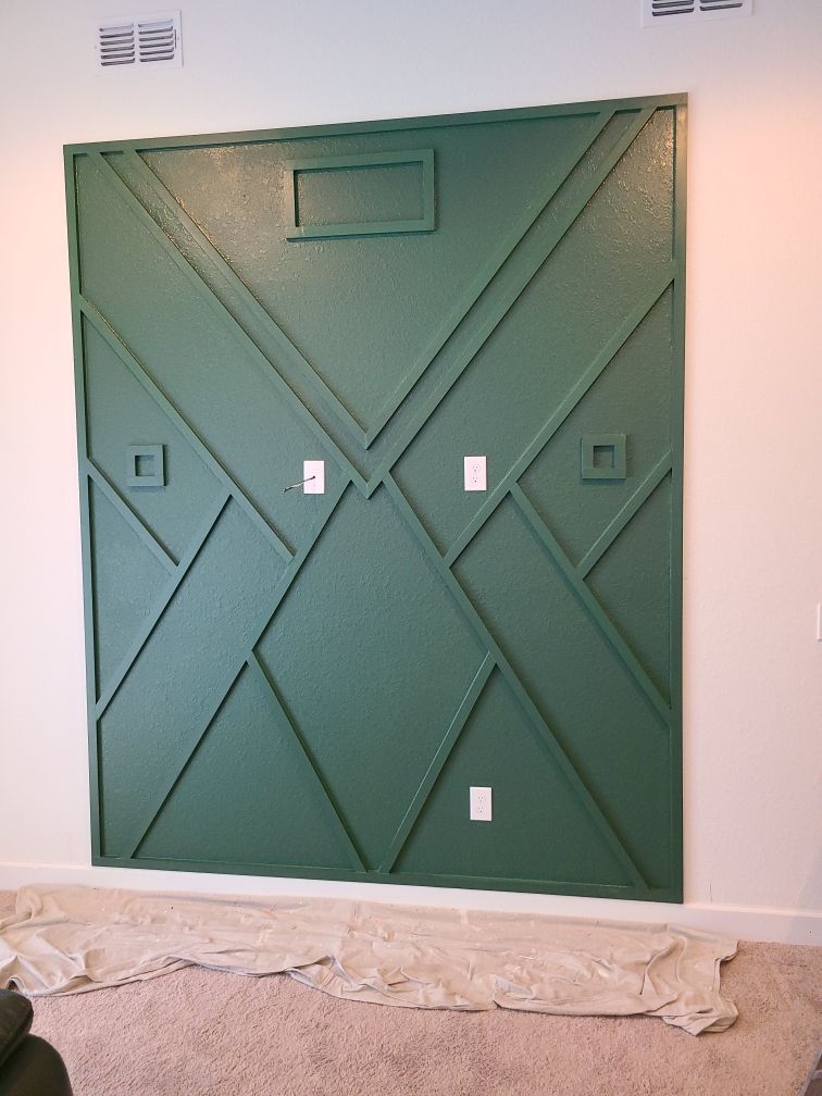 A green wall with a geometric pattern on it