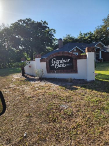A sign that says garner oaks in front of a house