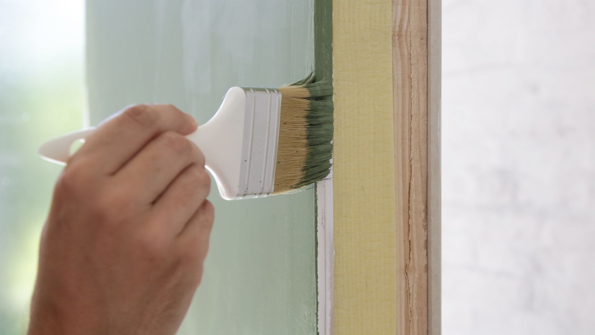 A person is painting a door with a brush.