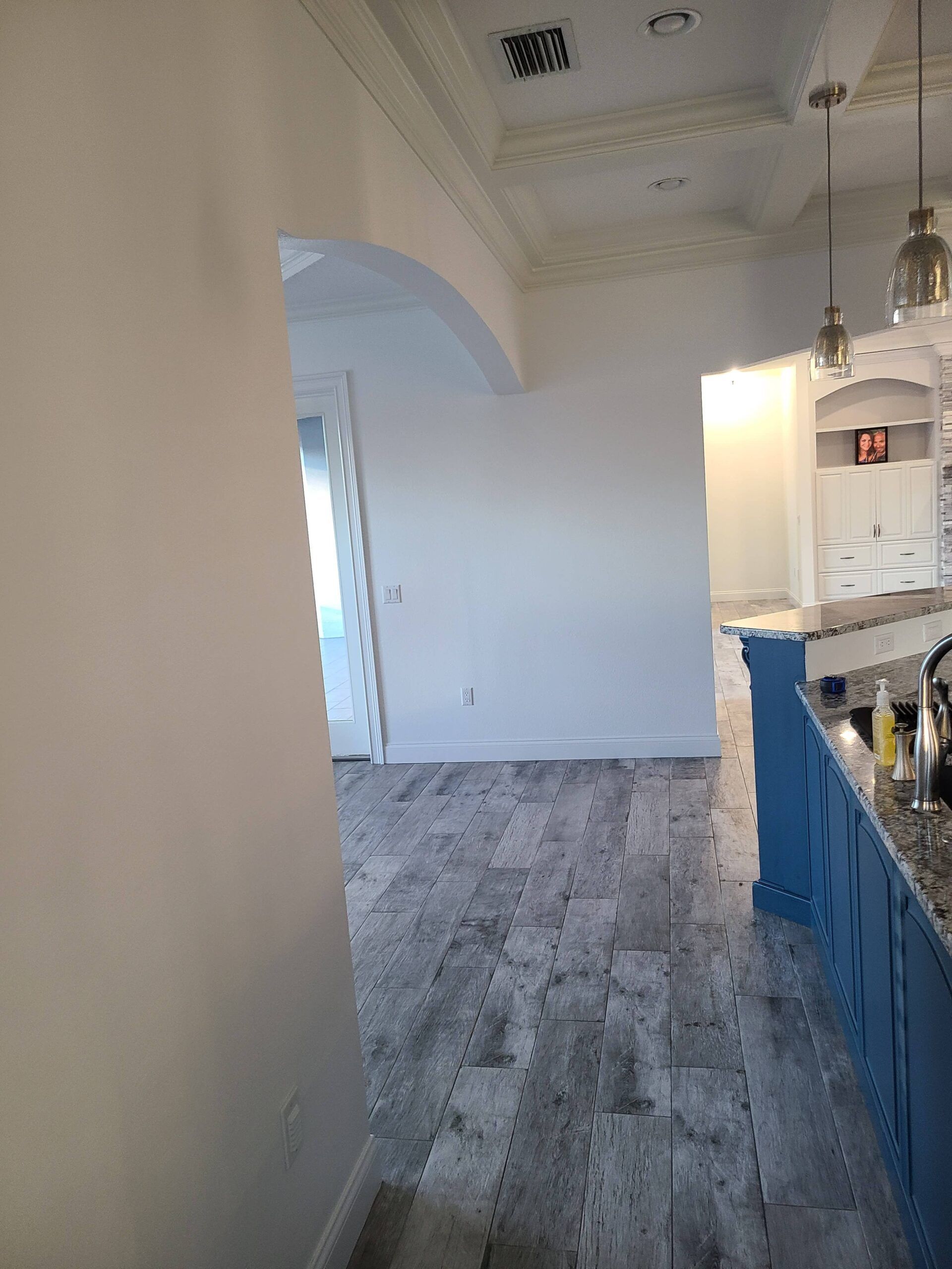 A kitchen with a blue island and a white counter top.