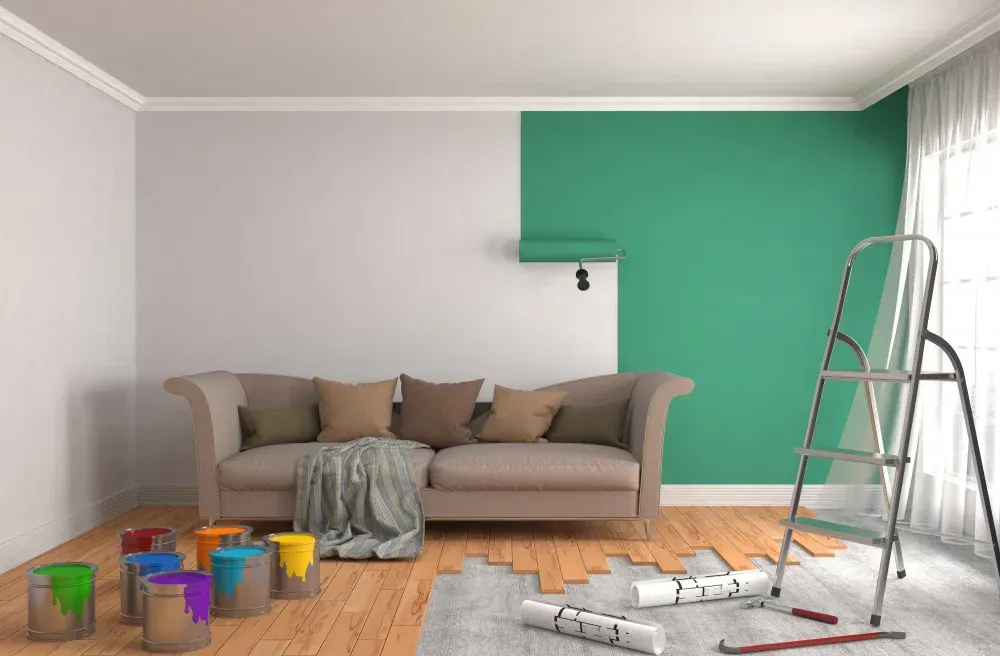A living room is being painted with a couch and a ladder.