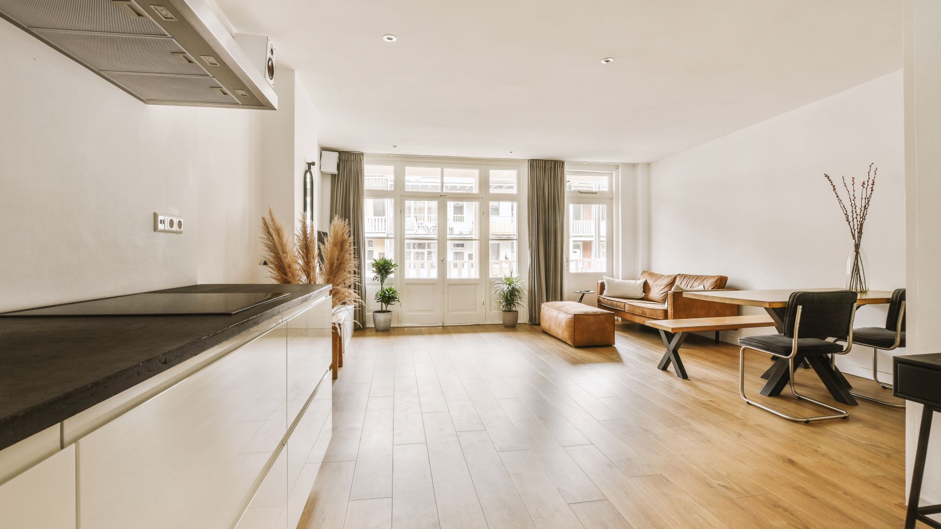 A living room with a couch , table , chairs and a kitchen.