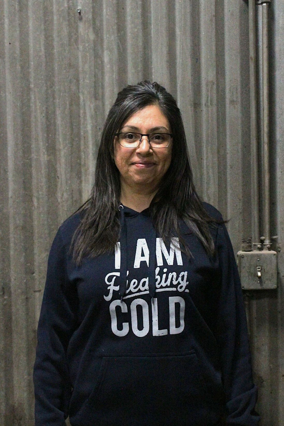 Woman in glasses and navy sweatshirt that reads