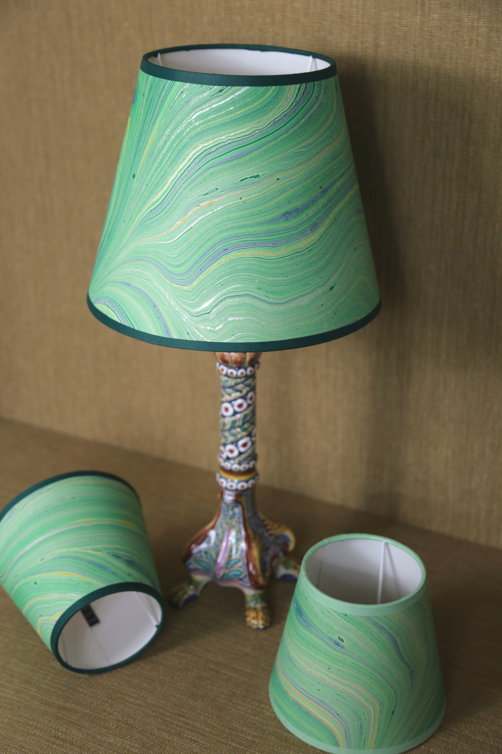 Groene gemarmerde lampenkap op een sierlijke lampvoet met extra lampenkappen.