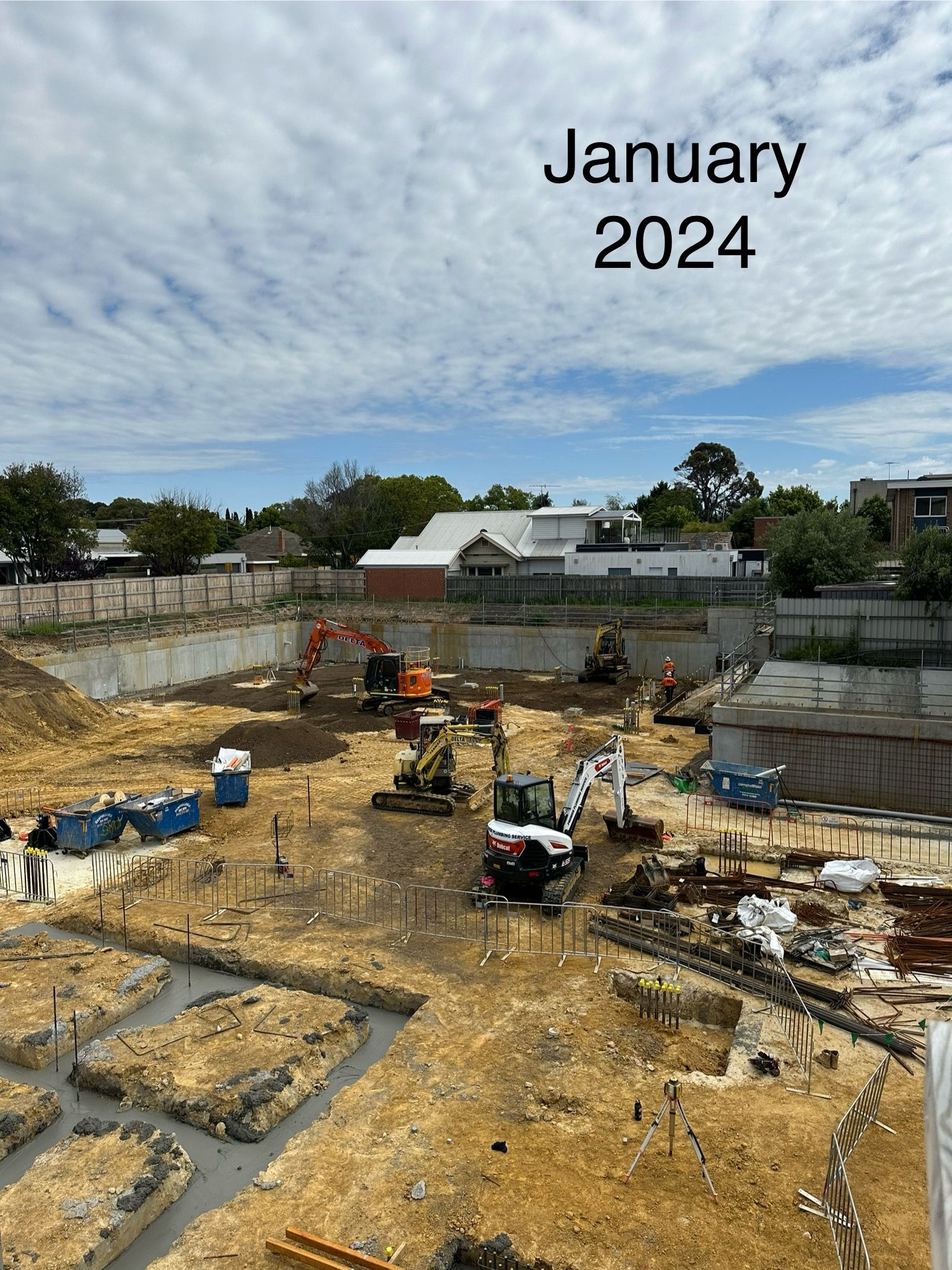Construction site with excavators, foundation work; blue sky with clouds; January 2024.