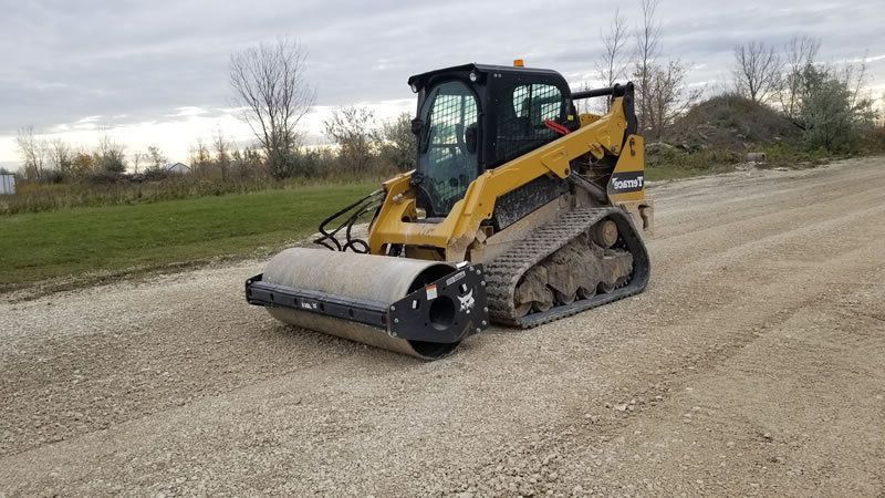 A bulldozer is digging a trench with a yellow hose attached to it.