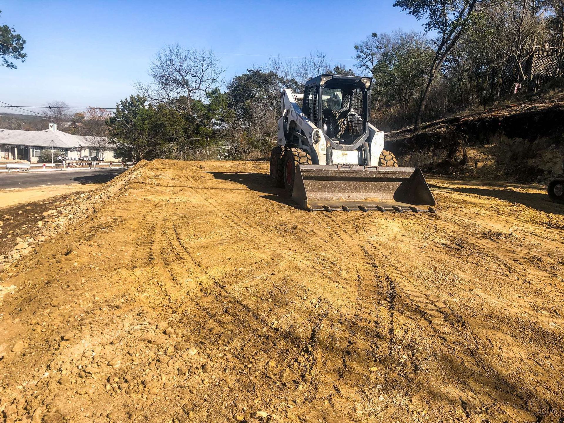 A bulldozer is digging a trench with a yellow hose attached to it.