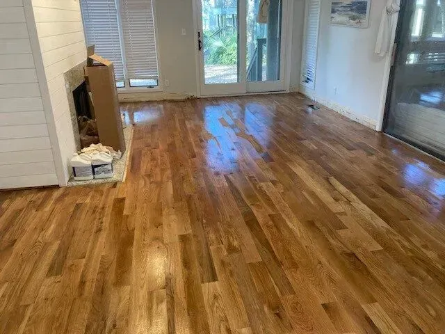 A living room with hardwood floors and a fireplace.