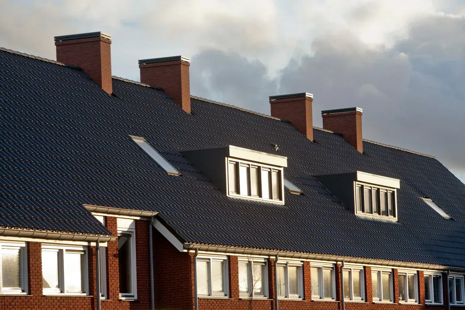 A row of brick houses with a black roof