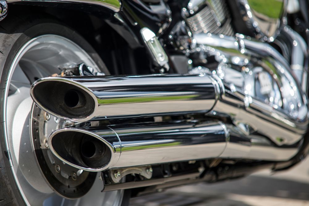 Chrome Motorcycle Exhaust Pipes on a Black and Silver Bike — Warners Bay Tyre & Mechanical in Warners Bay, NSW