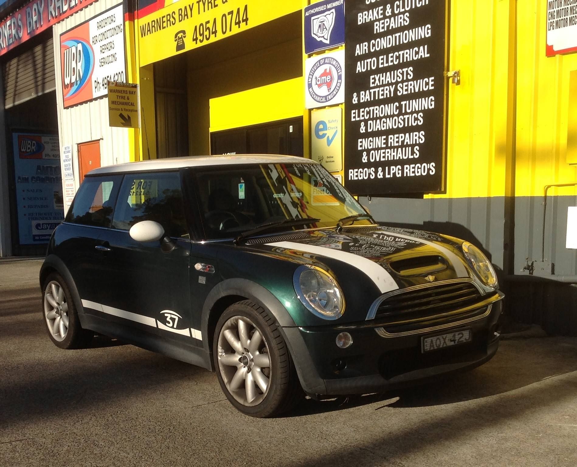 Green Mini Cooper Parked Outside a Yellow Auto Repair Shop — Warners Bay Tyre & Mechanical in Warners Bay, NSW