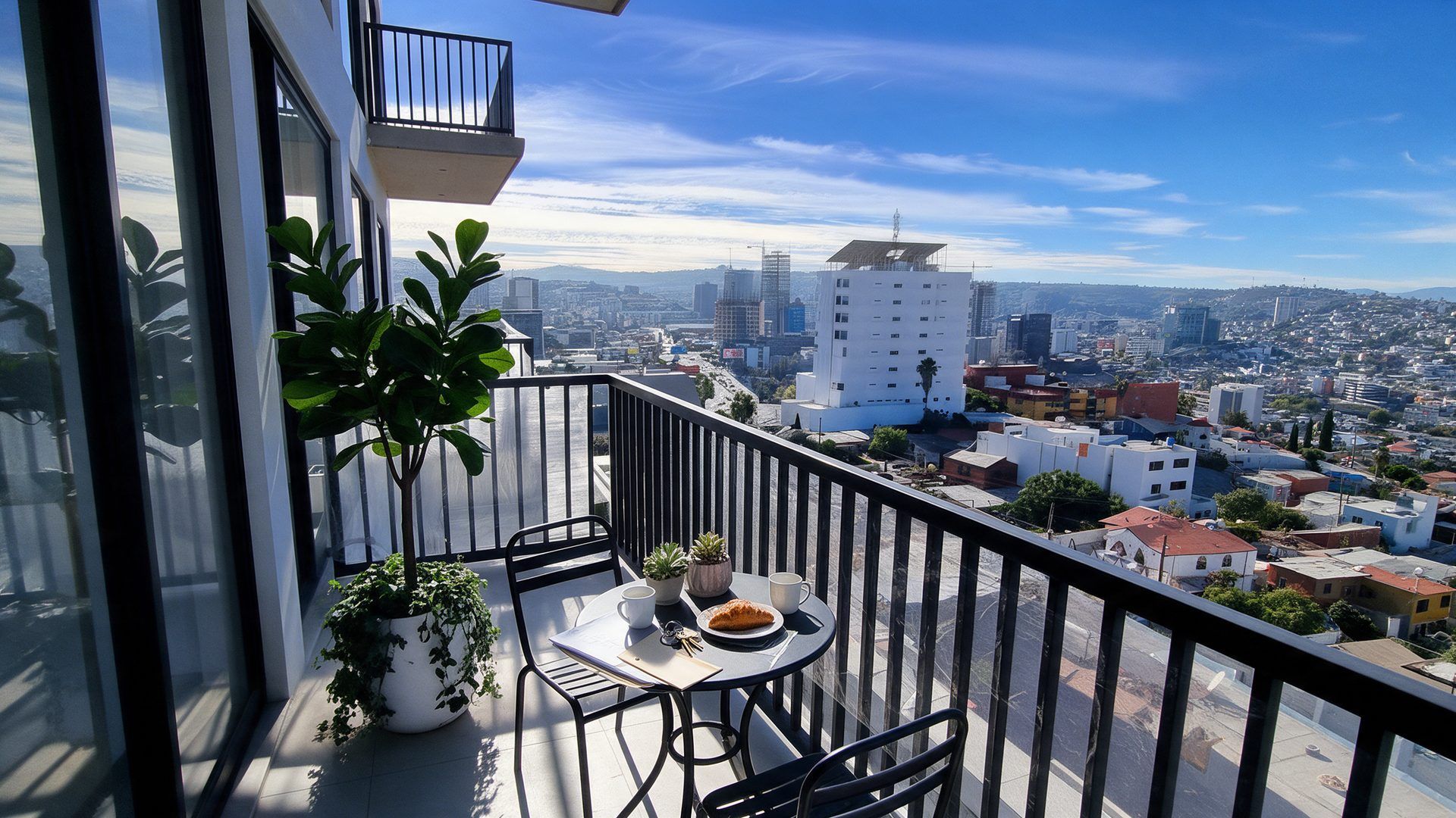 Balcón de un departamento con vista a Tijuana, llaves y documentos de crédito sobre una mesa