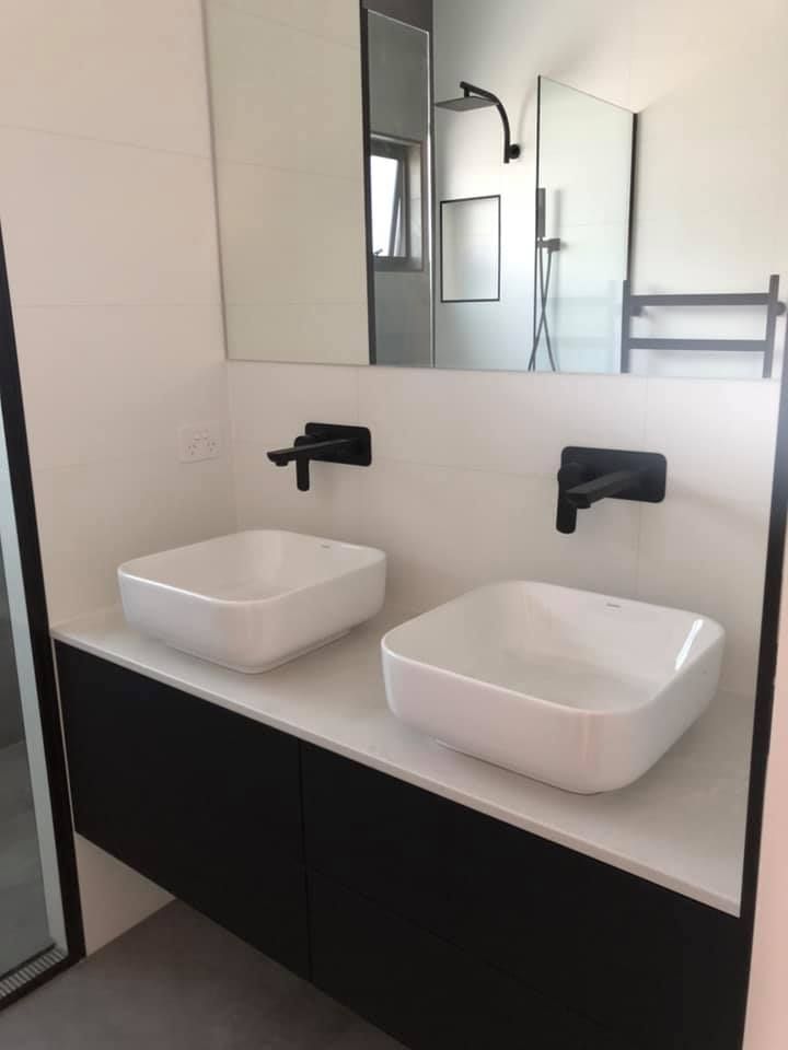 A bathroom with two sinks and a mirror