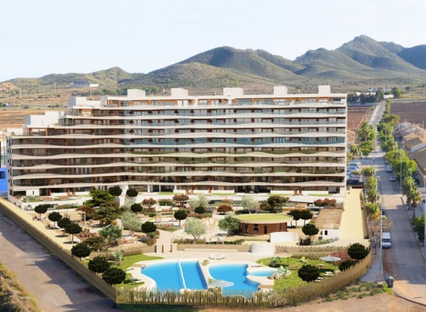 Modern multi-story apartment building with pool, landscaping, and mountain backdrop.
