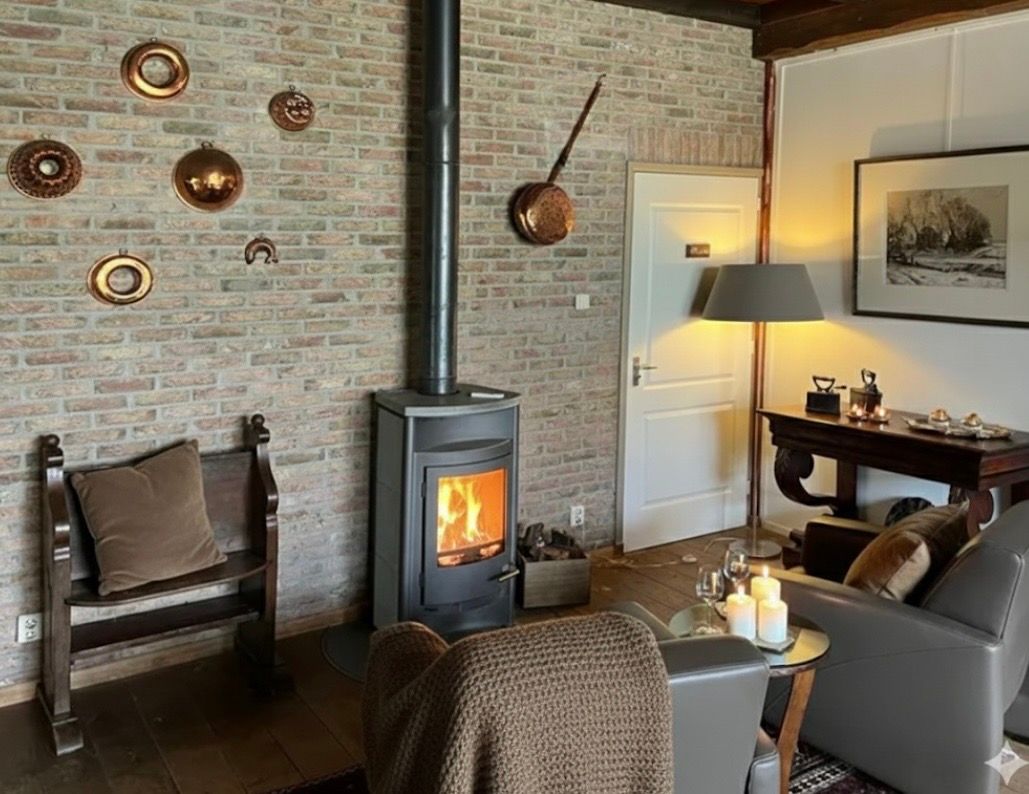 Cozy living room with brick wall, fireplace, and rustic decor.