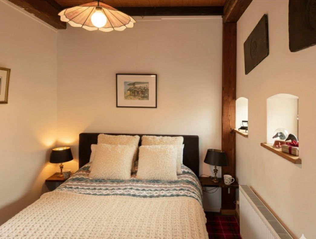 Cozy bedroom with a double bed, nightstands, and a decorative light fixture.