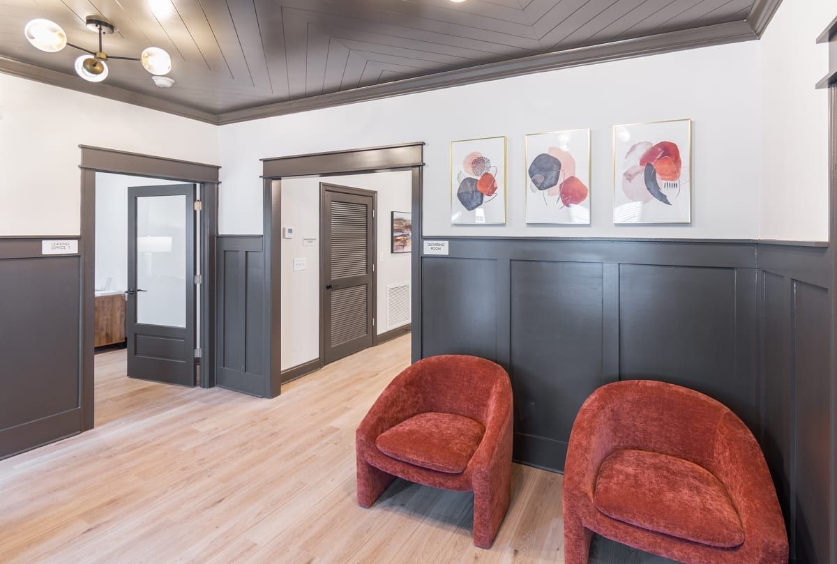 Two red chairs and paintings on the wall at The Indigo Apartments in Chattanooga, TN.