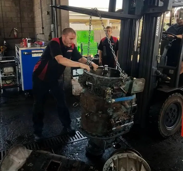 a man is working on a forklift in a garage .