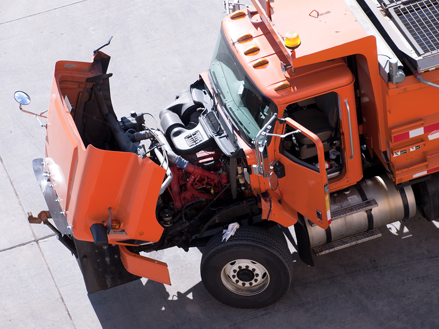an orange truck with the hood up and the door open