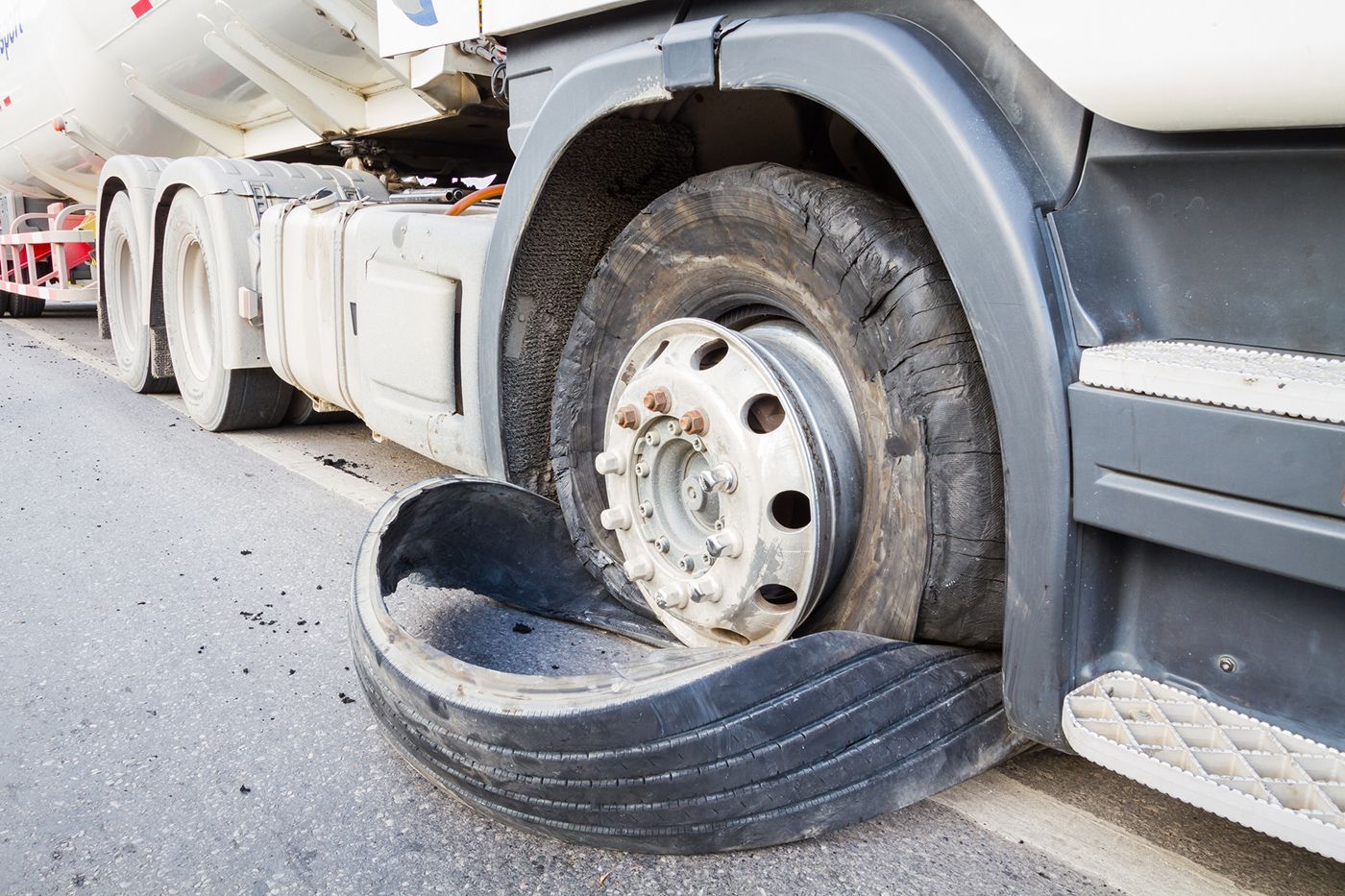 A truck with a flat tire on the side of it.