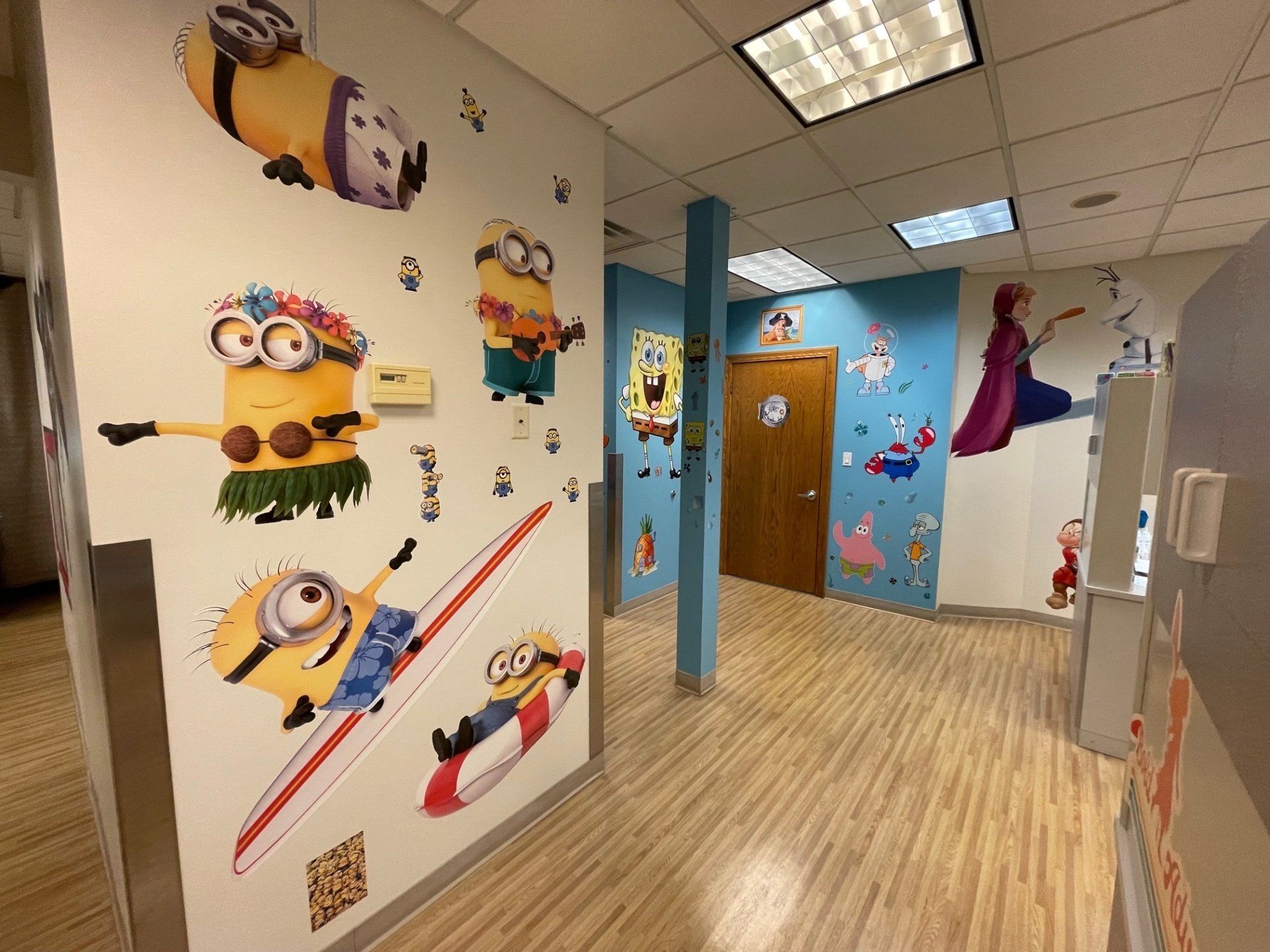 A hallway with spongebob and minions stickers on the wall.