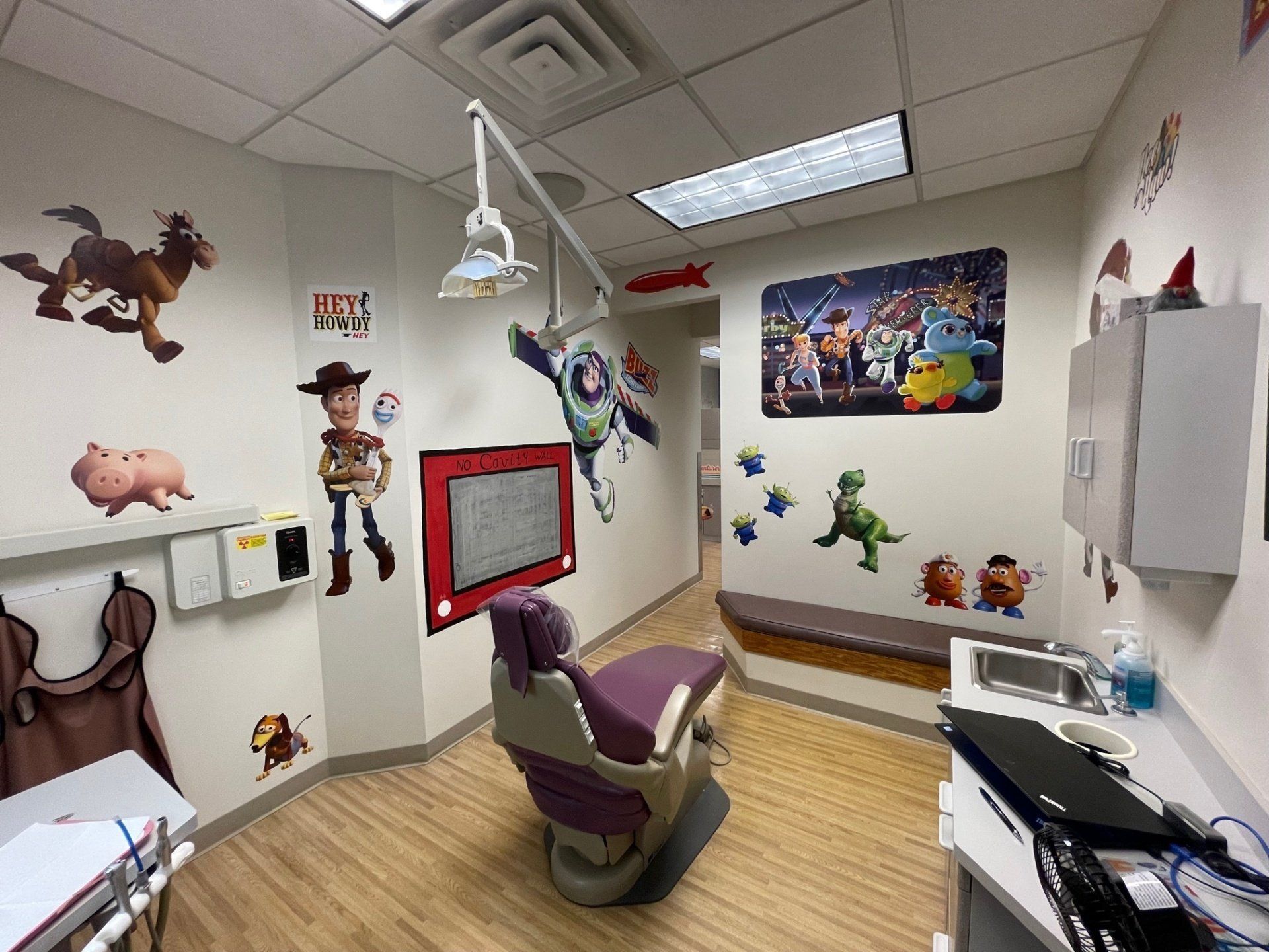 A dental office with toy story stickers on the walls.