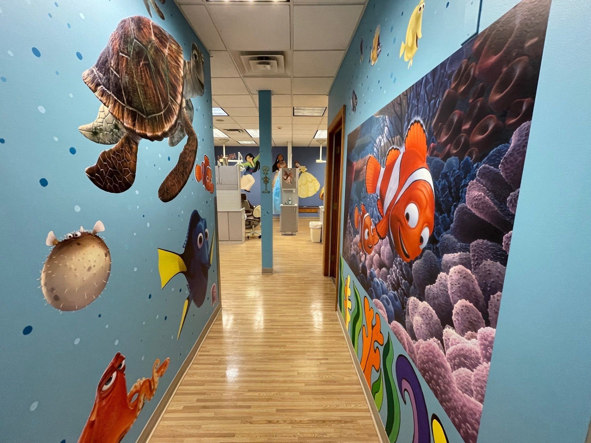 A hallway with a painting of a turtle and a clown fish on the wall.