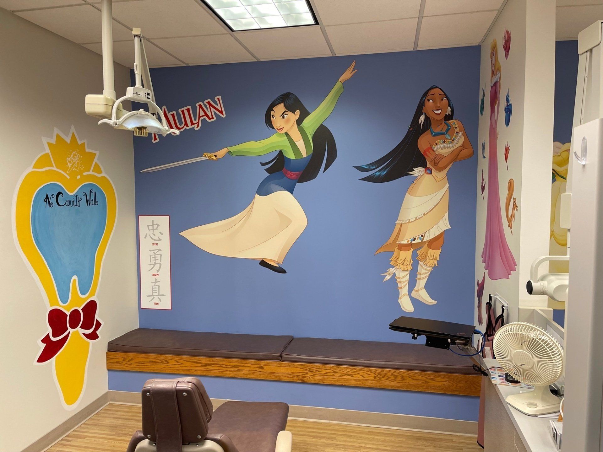 A dental office with a mural of mulan and pocahontas on the wall