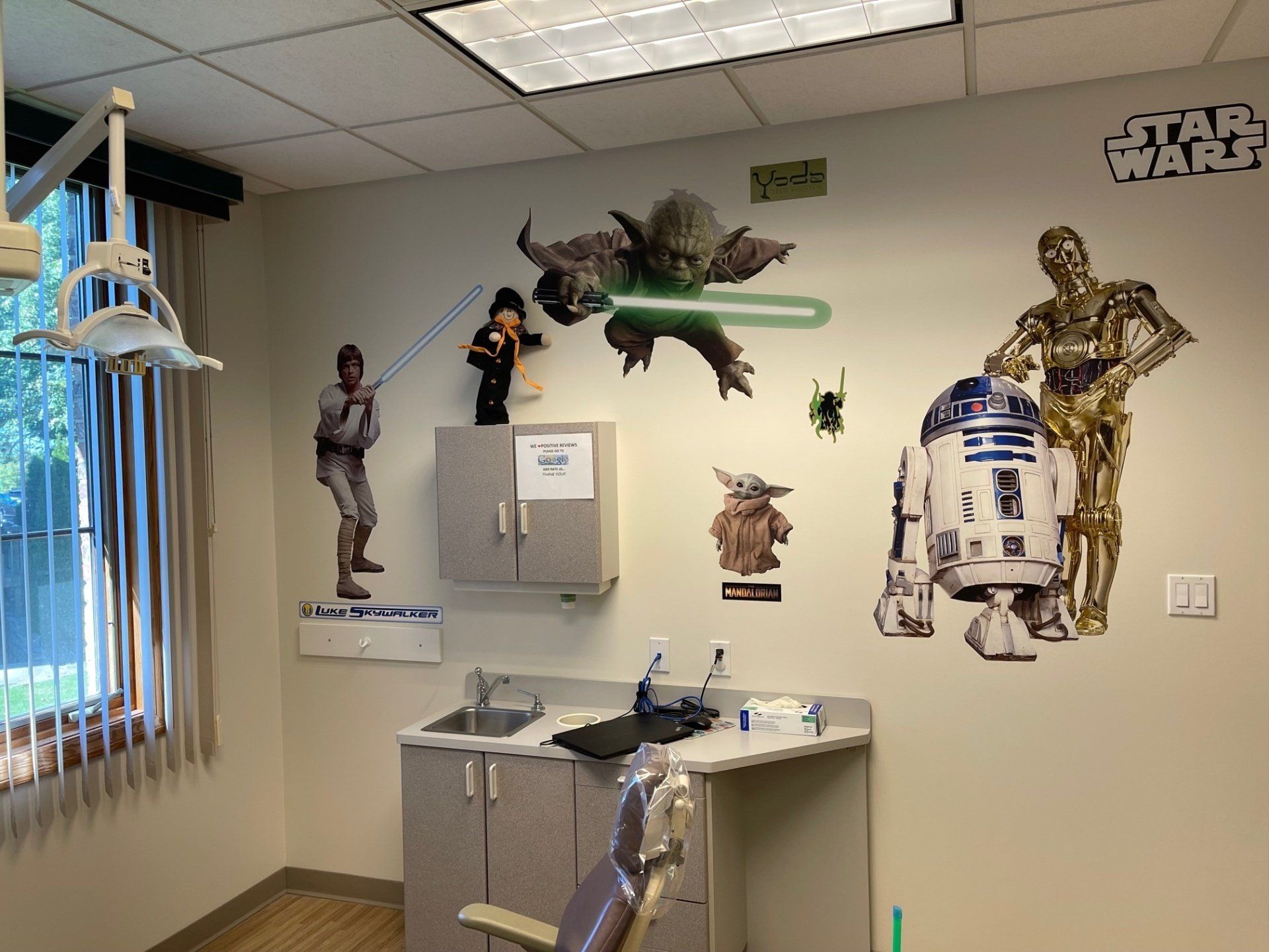 A dental office with a lot of star wars stickers on the wall.