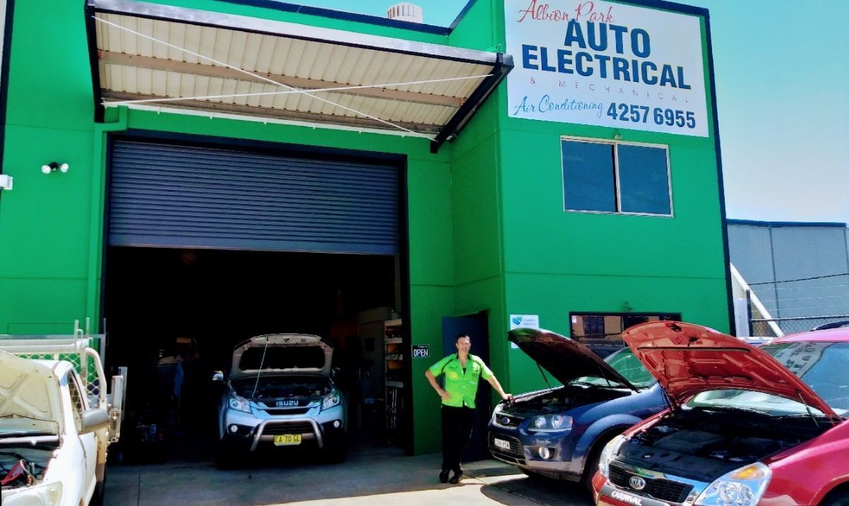A Red Car Is Parked In Front Of A Building That Says Auto Electrical — Albion Park Auto Electrical & Mechanical In Albion Park Rail, NSW