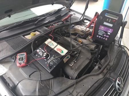 The Hood Of A Car Is Open And A Battery Is Being Charged — Albion Park Auto Electrical & Mechanical In Albion Park Rail, NSW