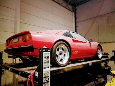 A Red Sports Car Is Parked On Top Of A Trailer In A Garage — Albion Park Auto Electrical & Mechanical In Albion Park Rail, NSW
