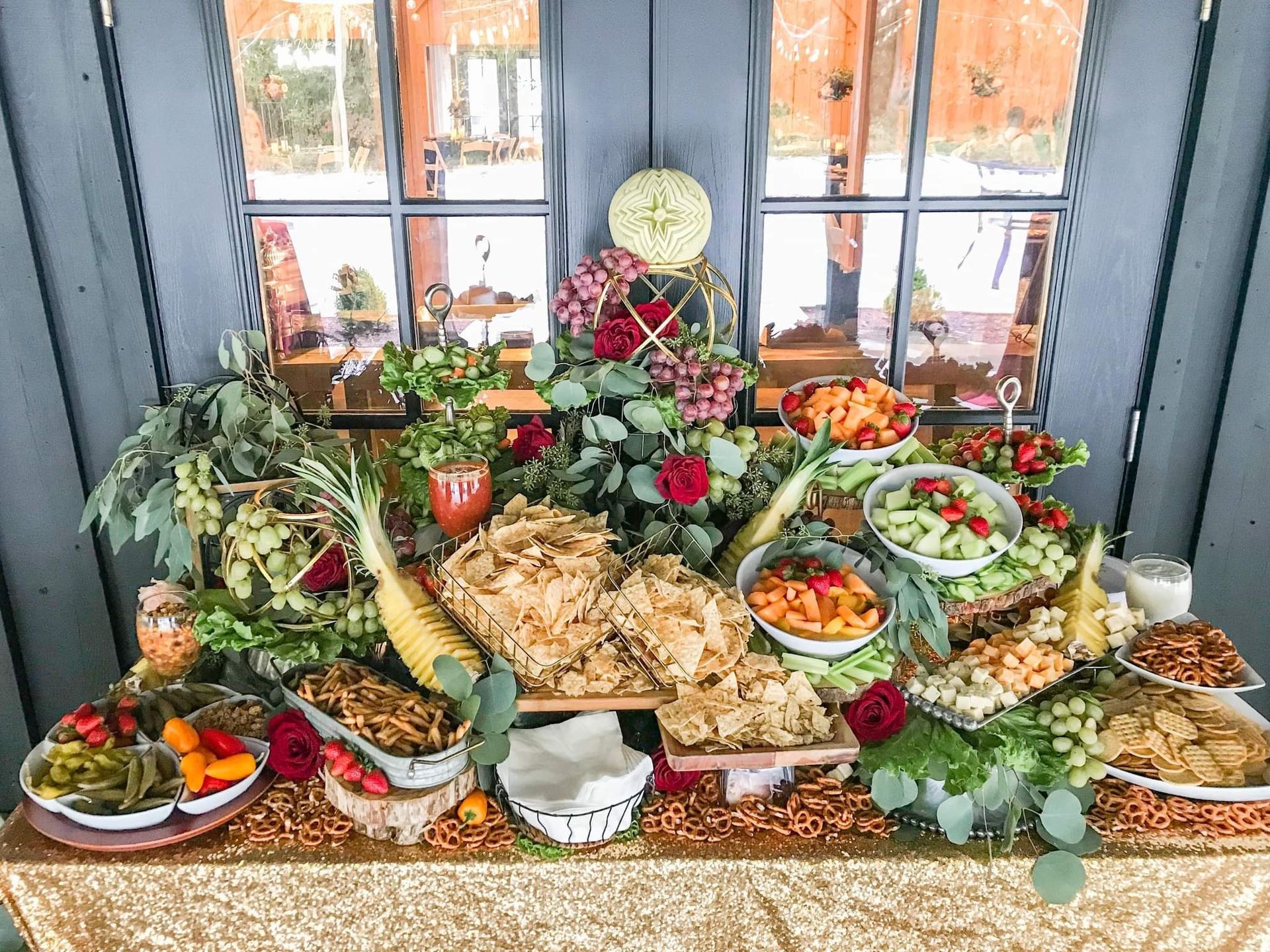 A buffet table filled with lots of food and flowers.